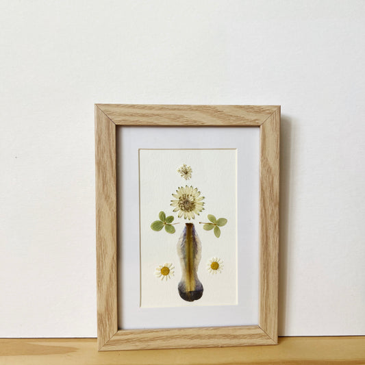 Pressed flower picture frame with Iris Hydrangea Astrantia and Margarita flowers on white background inside natural wood frame